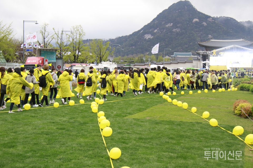 14일 오후 4시 서울 광화문광장에서 열린 ‘노란리본 만들기’ 플래시몹에 참여한 시민들이 노란리본 대형을 만들기 위해 들어서고 있다 Ⓒ투데이신문