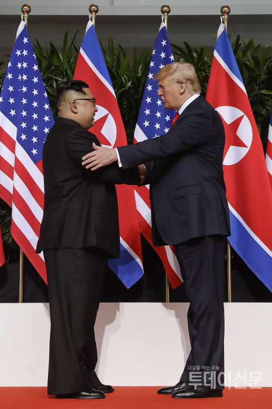 도널드 트럼프 미국 대통령과 북한 김정은 국무위원장이 12일 북미정상회담이 열린 싱가포르 카펠라 호텔에서 만나 악수하고 있다. ⓒAP