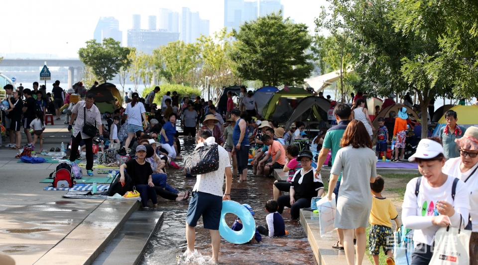 1일 오후 서울 여의도한강공원 물빛광장 인근에서 시민들이 더위를 피해 그늘로 모여들고 있다 ⓒ뉴시스