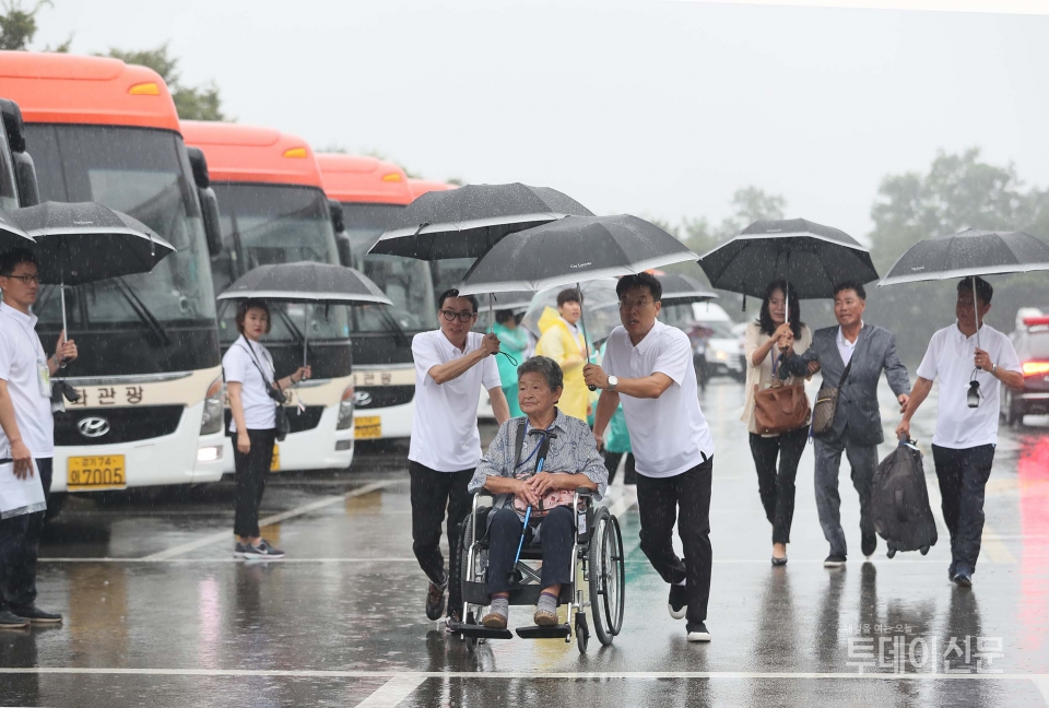 24일 오전 강원도 속초시 한화리조트에서 제21차 이산가족 상봉행사 2회차 상봉단이 우산을 쓴 채 버스로 향하고 있다 ⓒ뉴시스