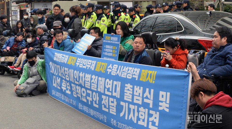 지난해 3월 21일 서울 영등포구 여의도동 더불어민주당 당사 앞에서 2017대선장애인차별철폐연대 회원들이 기자회견을 열고 장애등급제 폐지를 요구하고 있다 ⓒ뉴시스