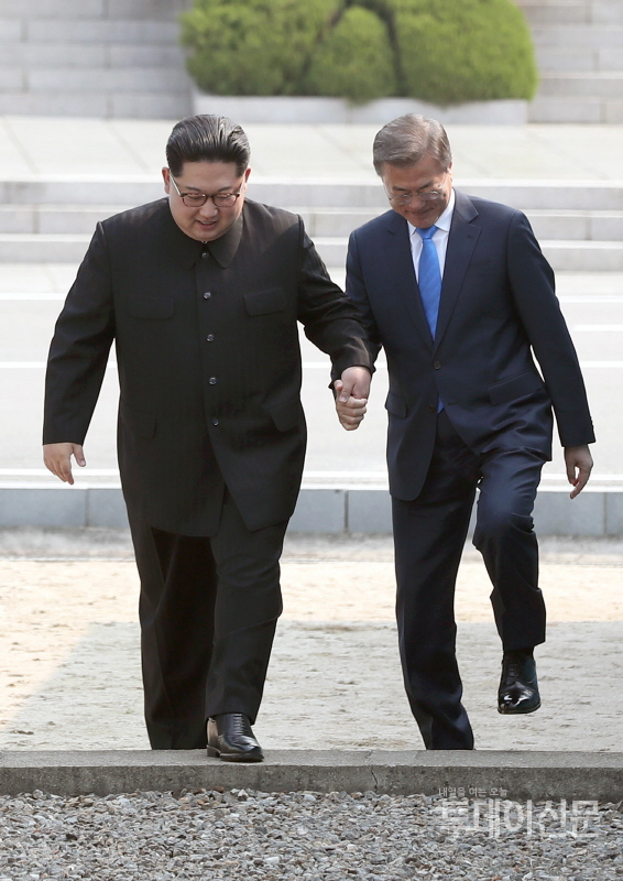 문재인 대통령과 김정은 북한 국무위원장이 지난 4월 27일 경기 파주 판문점에서 손을 잡고 함께 군사분계선을 넘고 있다. ⓒ뉴시스