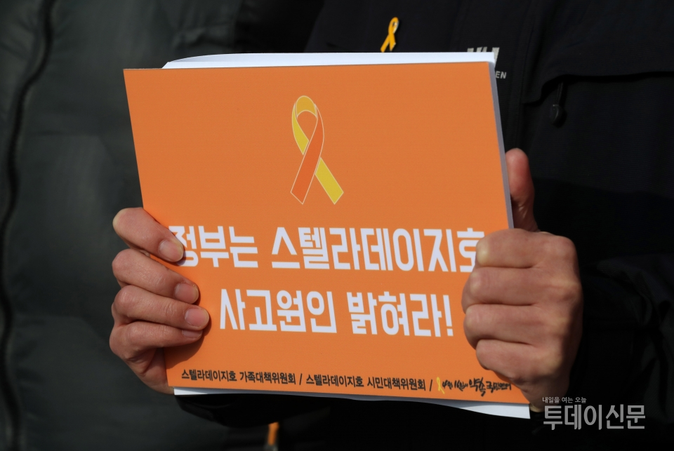 지난해 1월 2일 서울 종로구 청와대 분수대 앞에서 열린 ‘스텔라데이지호 10만인 국민서명 전달 기자회견’에서 한 참가자가 침몰원인 규명을 촉구하는 피켓을 들고 있다. ⓒ뉴시스