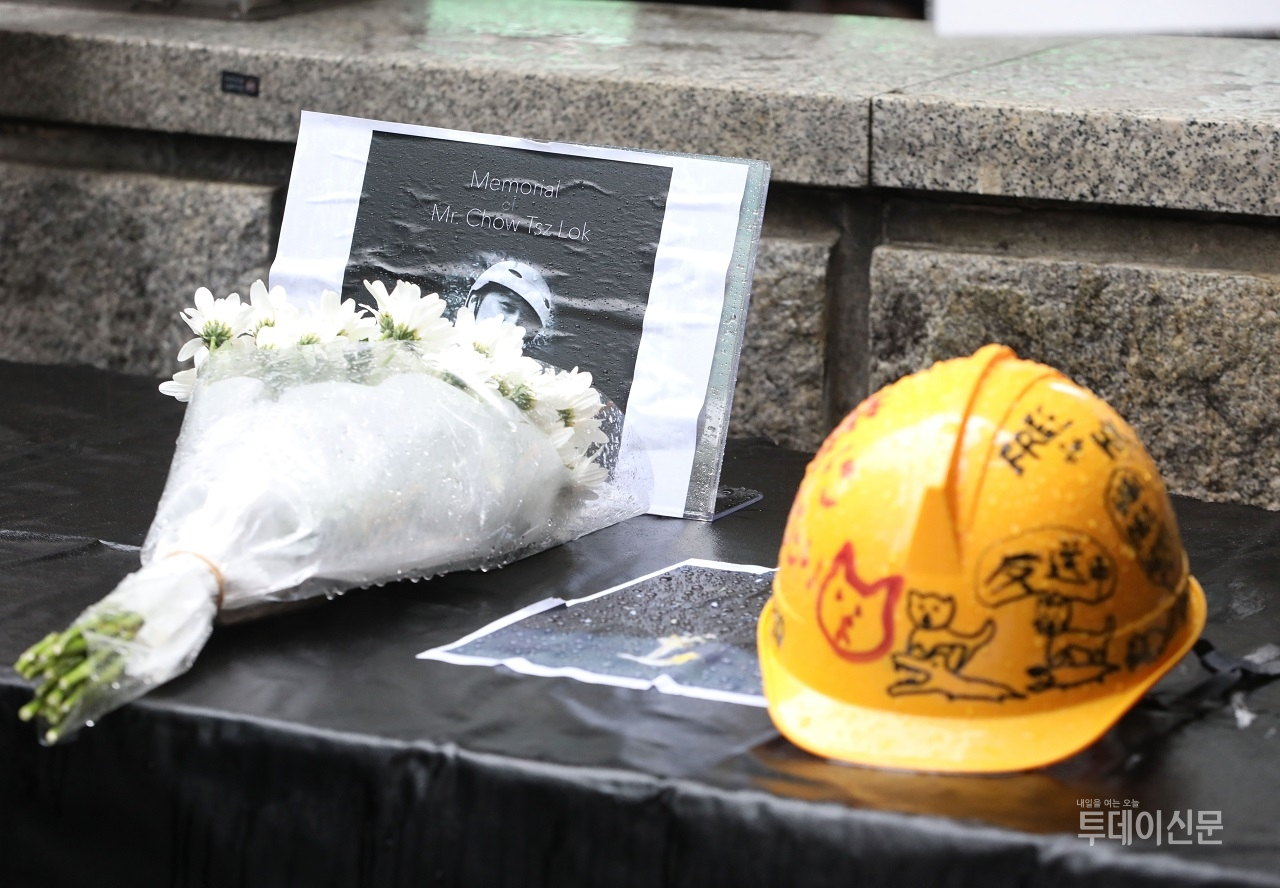 지난달 17일 서울 마포구 홍대입구역 9번 출구 앞에 놓인 홍콩 민주화 시위에서 희생된 시민을 추모하는 꽃과 안전모 ⓒ뉴시스