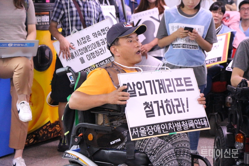 지난 2018년 9월 4일 서울지하철 1·2호선 시청역에서 열린 ‘제3차 지하철 그린라이트 시위’에 참가한 장애인이 피켓을 들고 있다. ⓒ투데이신문