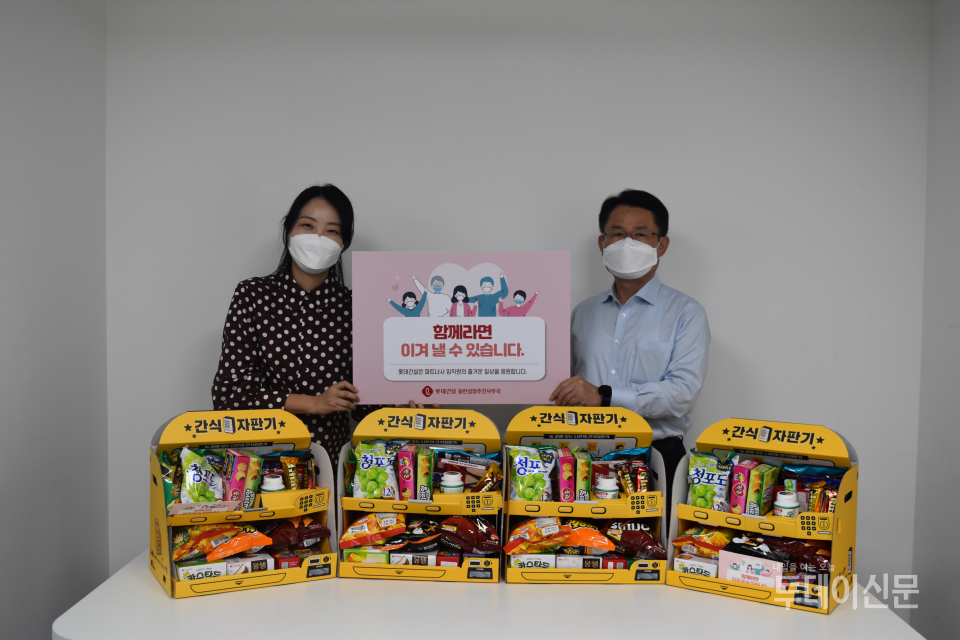 롯데건설이 파트너사에 제공한 롯데제과 간식 자판기(롯데건설 외주구매본부장 석균성 전무(우측))ⓒ롯데건설