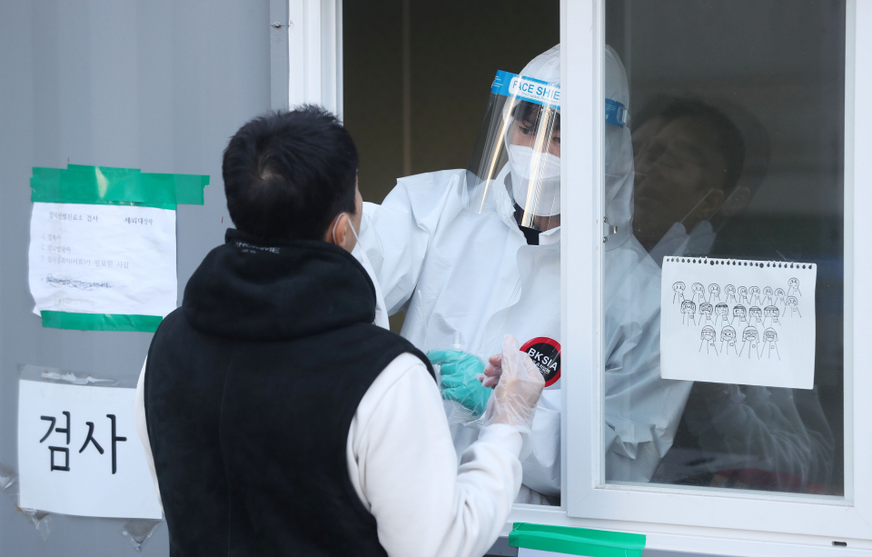 의료진이 지난 24일 서울 동대문구 청량리역 광장에 마련된 코로나바이러스감염증-19(코로나19) 임시 선별검사소에서 의료진이 시민의 검체를 채취하고 있다. ⓒ뉴시스