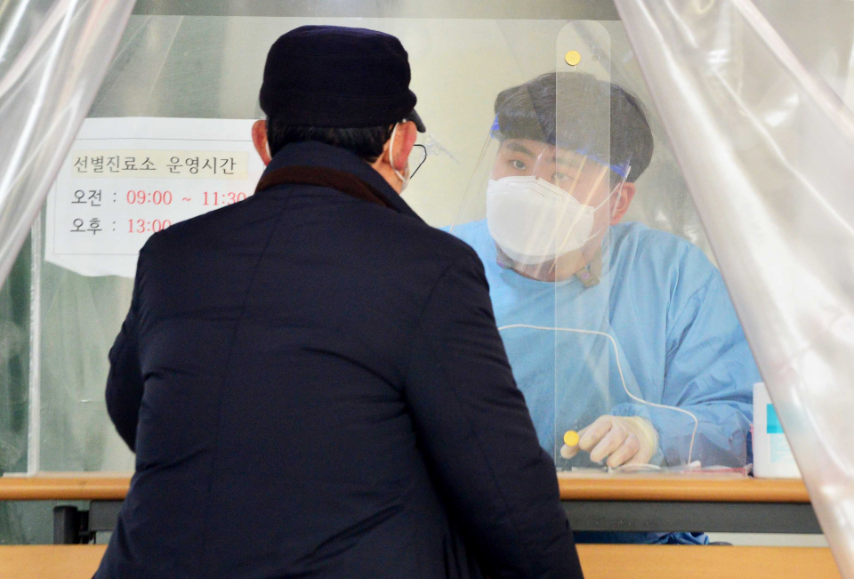 방역 공무원이 지난 12일 광주 서구보건소 코로나바이러스감염증-19(코로나19) 선별진료소에서 검사를 위해 방문한 시민을 상대로 문진하고 있다. ⓒ뉴시스