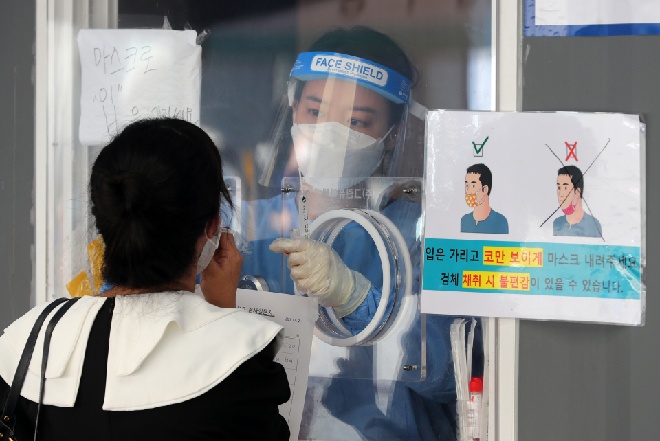 한 시민이 21일 서울 중구 서울역광장에 설치된 코로나바이러스감염증-19(코로나19) 임시선별검사소에서 검사를 받고 있다. ⓒ뉴시스
