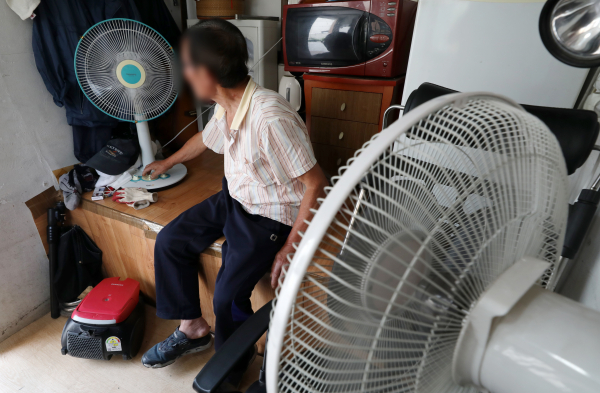 서울 시내 한 아파트 경비실에서 경비원이 선풍기를 이용해 더위를 식히고 있다.