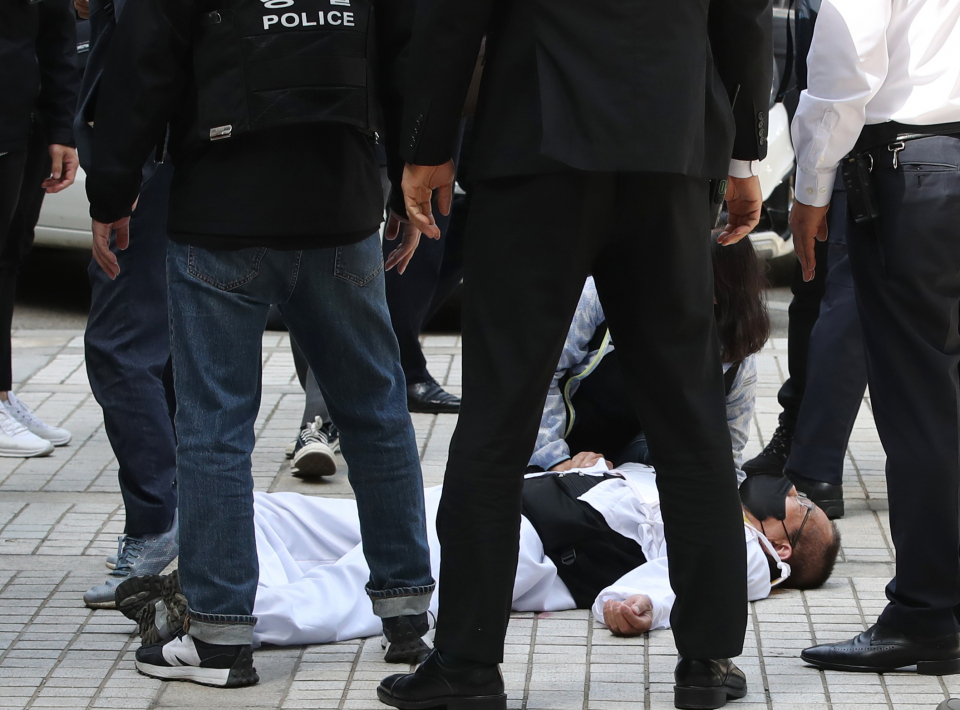 김정남 공공운수노조 아시아나KO 지부장이 서울 서초구 서울중앙지방법원 출입문 앞에서 피켓 시위중 법원 직원들과 몸싸움을 하다 쓰러져 있다.