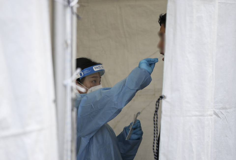 21일 오전 서울 종로구 흥인지문 인근에 설치된 서울시 찾아가는 선별진료소를 찾은 시민들이 검사를 받고 있다.