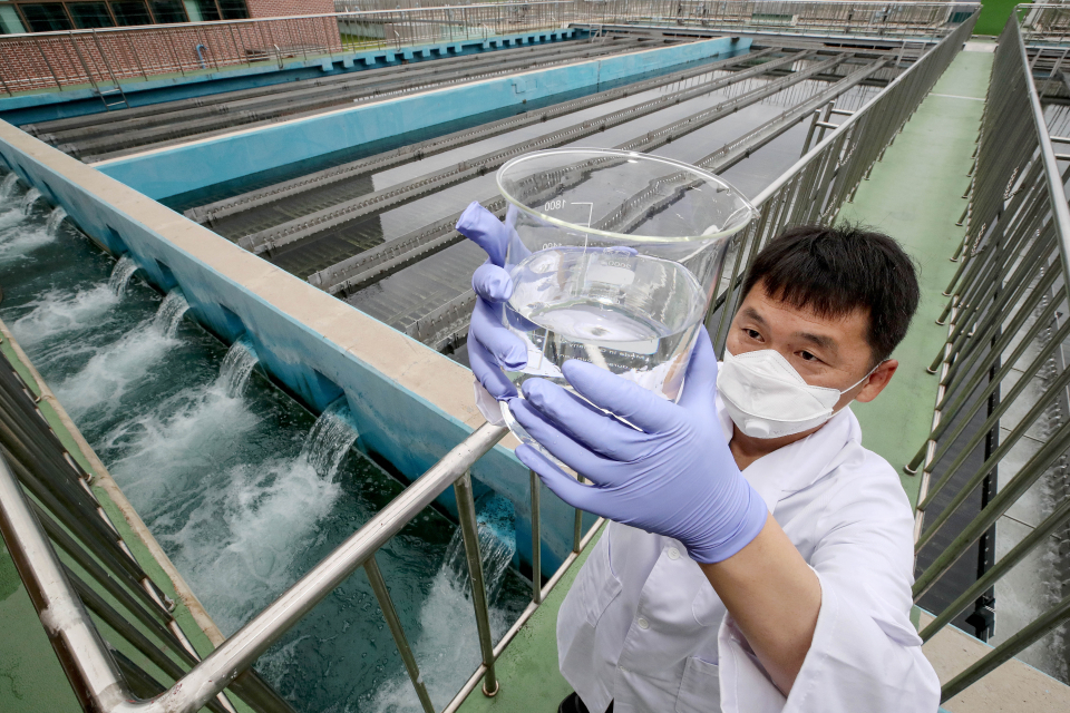 서울 성동구 뚝도아리수정수센터 침전지에서 연구사가 체수한 뒤 육안으로 수질을 검사하고 있다.