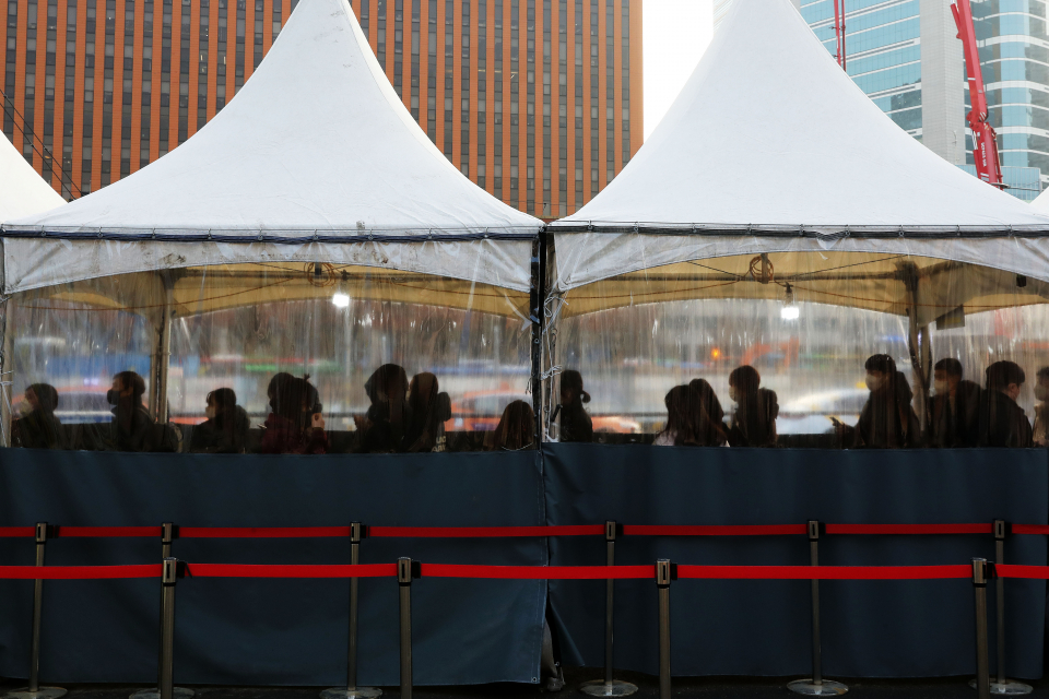 코로나19 신규 확진자가 1만3012명으로 역대 최다를 기록한 26일 오전 서울 중구 서울역광장 임시선별검사소에서 시민들이 검사를 받기 위해 대기하고 있다.