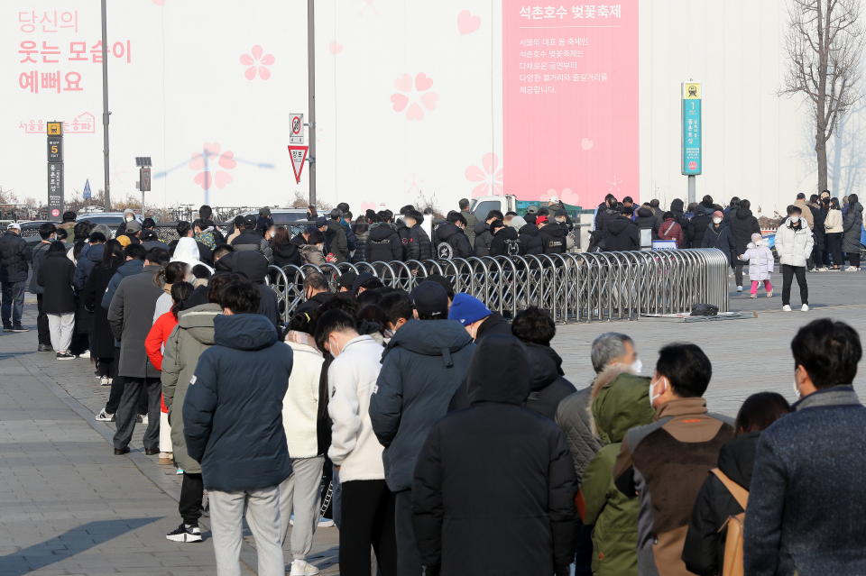 코로나19 신규 확진자가 5만3926명으로 집계된 11일 오전 서울 송파구 올림픽공원 평화의문 광장 임시선별검사소에서 시민들이 검사를 받기 위해 대기하고 있다.