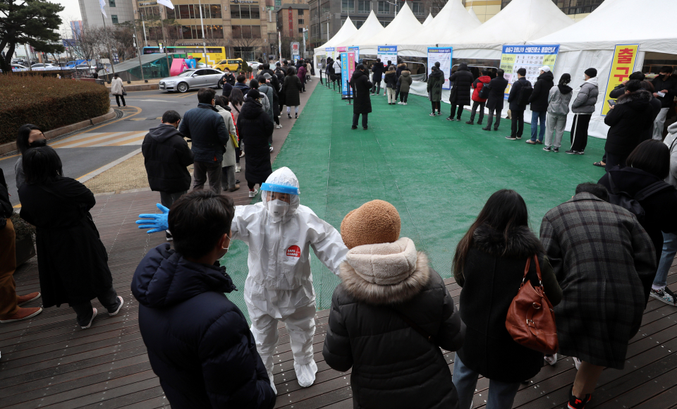 코로나19 신규 확진자수가 닷새째 5만명대를 기록한 14일 오전 서울 송파구 선별진료소에서 시민들이 코로나19 검사를 받기 위해 길게 줄지어 서 있다.