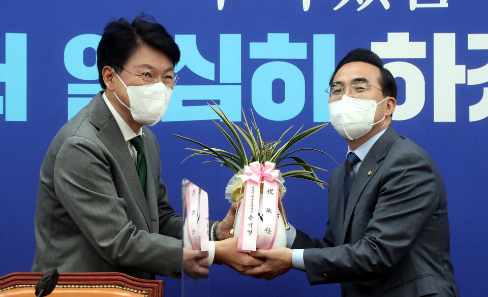 박홍근 더불어민주당 신임 원내대표가 25일 서울 여의도 국회에서 장제원 대통령 당선인 비서실장 예방을 받고 윤석열 당선인의 축하 난을 전달받고 있는 모습 [사진제공=뉴시스]<br>