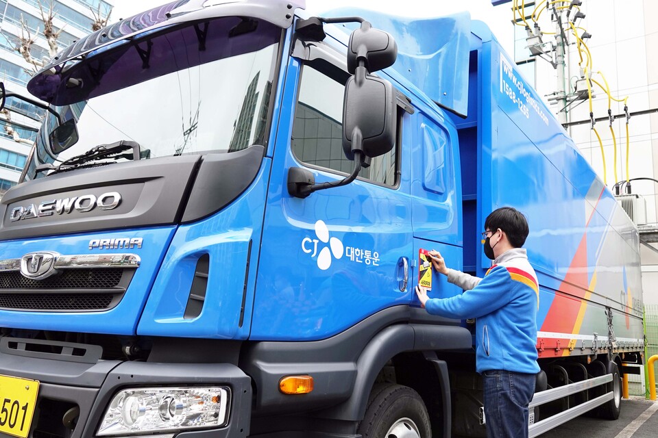 CJ대한통운이 직원이 ‘사각지대 주의’ 스티커를 부착하고 있다. [사진제공=CJ대한통운]