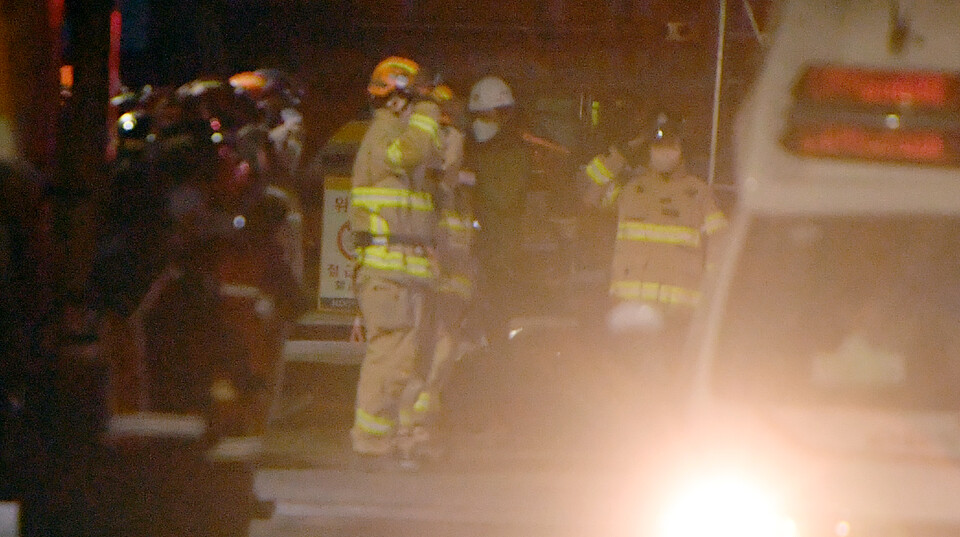 광주 HDC현대산업개발 아파트 신축 공사현장 붕괴사고 29일째인 지난 2월 8일, 구조대원들이 사고건물 26층에서 수습된 매몰자를 태운 구급차량을 향해 경례하고 있다. [사진제공=뉴시스]