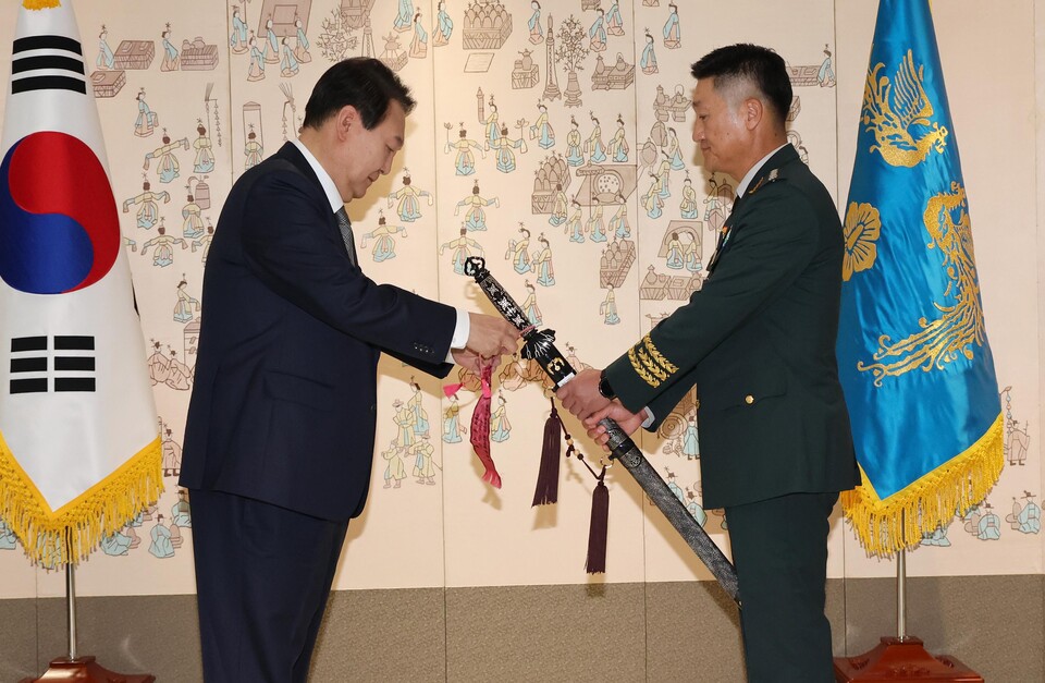 윤석열 대통령이 27일 오전 용산 대통령실 청사에서 열린 장성진급 보직신고 및 삼정검 수치 수여식에서 안병석 연합사 부사령관의 삼정검에 수치를 달아주고 있다. [사진제공=뉴시스]