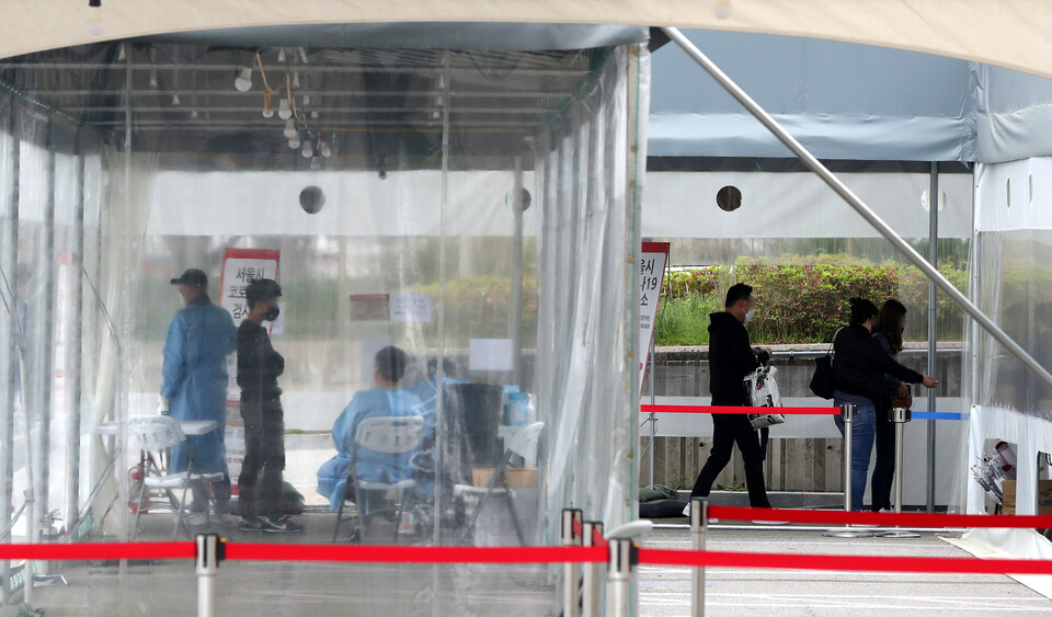 서울 송파구 잠실종합운동장 제2주차장 임시선별검사소에서 시민이 코로나19 검사를 받기위해 줄 서 있다. [사진제공=뉴시스]<br>