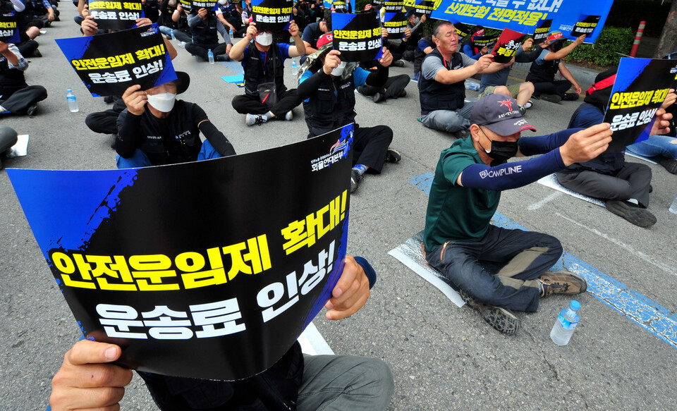 광주 서구 기아자동차 제1공장 남문에서 민주노총 공공운수노조 화물연대 광주본부 소속 화물운수 노동자들이 총파업 승리 결의대회에 참석해 피켓을 흔들고 있다.&nbsp;[사진제공=뉴시스]