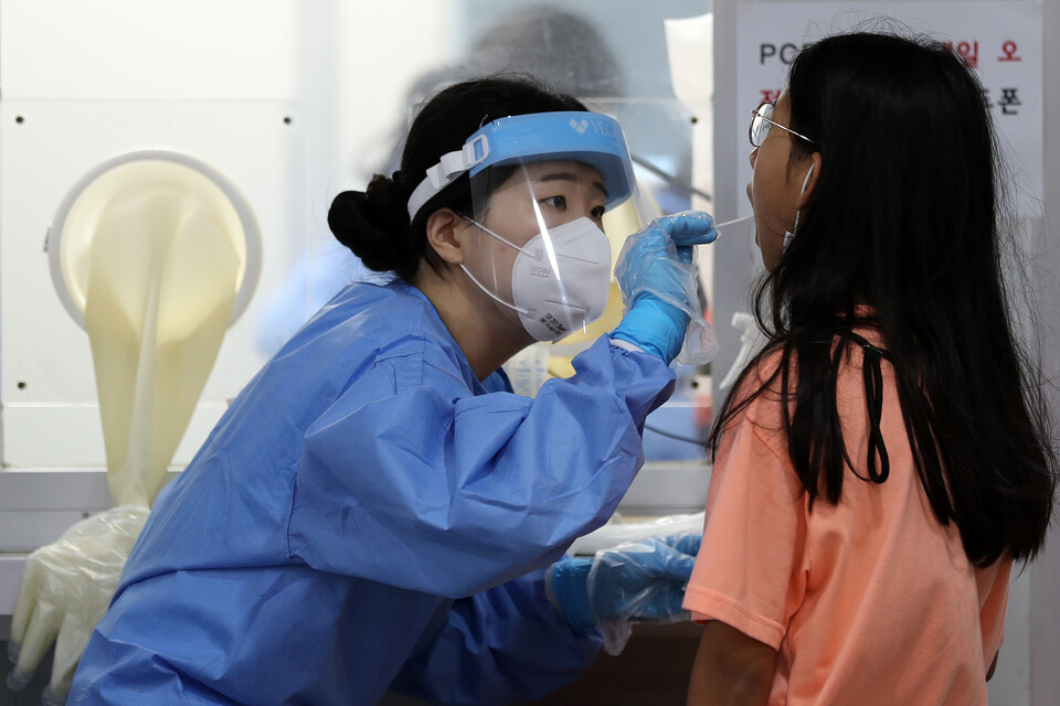 코로나19 신규 확진자가 11만1789명으로 집계된 2일 오전 서울 성북구보건소 선별진료소에서 의료진이 검체를 채취하고 있다. [사진제공=뉴시스]<br>