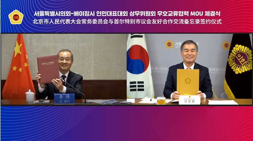 김현기 서울시의회의장(오른쪽)과 리웨이 베이징시 인민대표회 상무위원회 주임이 19일 진행된 화상회의에서 우호교류협력 MOU를 체결하고 있다. [사진제공=서울시의회]