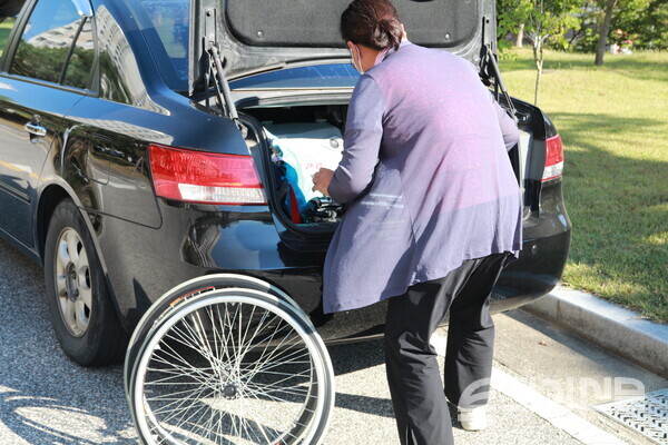 장애인 콜택시 배차에 실패한 지애씨를 돕기위해 어머니가 직접 휠체어를 옮긴 뒤 설치하고 있다.ⓒ투데이신문