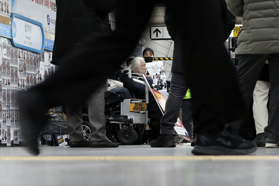 전국장애인차별철폐연대의 장애인 권리예산 확보를 위한 지하철 출근길 선전전이 펼쳐지는 서울 용산구 삼각지 역에서 시민들이 출근하고 있다 [사진제공=뉴시스]<br>