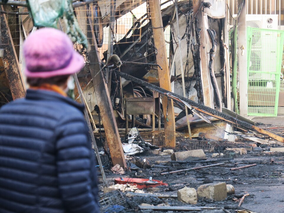 지난 5일 오전 인천 동구 현대시장에서 한 상인이 불에 탄 점포를 바라보고 있다. [사진제공=뉴시스]<br>