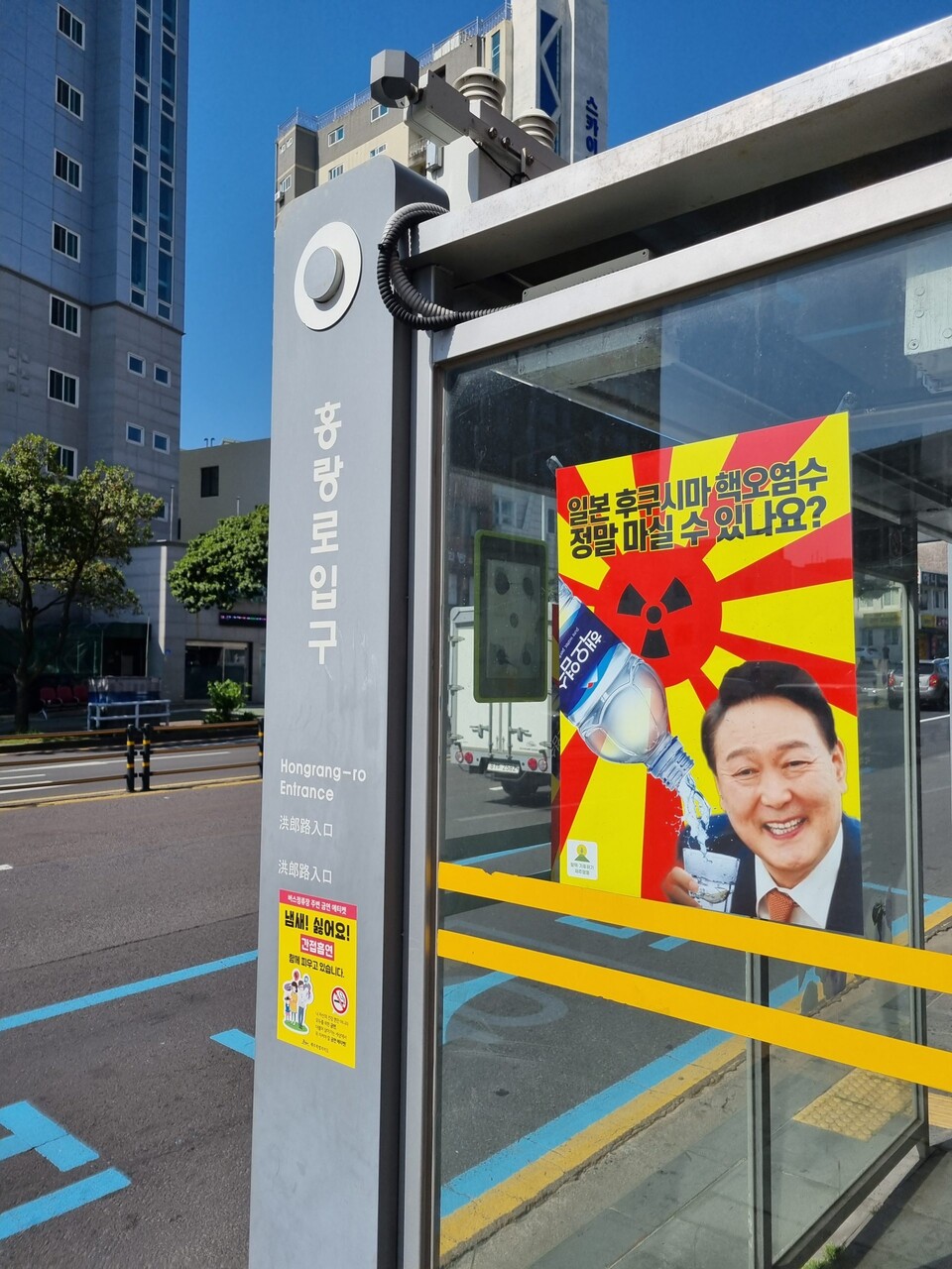 제주시 한 버스정류장에 윤석열 대통령이 일본 후쿠시마 핵 오염수를 마시려고 하는 모습이 담긴 합성 포스터가 부착돼 있다. [사진제공=제주환경운동연합]