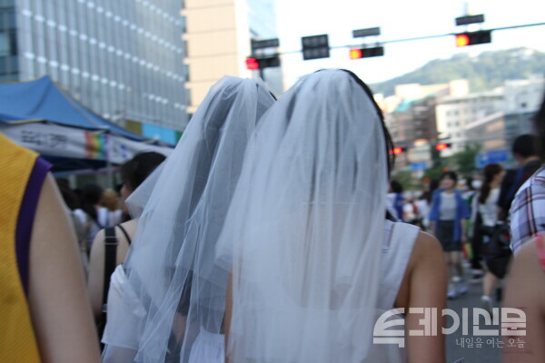 지난 1일 서울퀴어문화축제에서 웨딩드레스를 입은 두 여성이 행사 부스 쪽으로 걸어가고 있다.&nbsp;ⓒ투데이신문