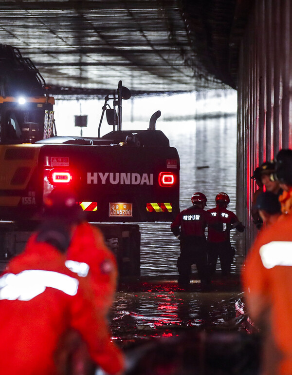 폭우로 침수된 충북 청주시 흥덕구 오송읍 궁평2지하차도에서 17일 해양 경찰, 소방 등 구조대원들이 도보 수색을 벌이고 있다.