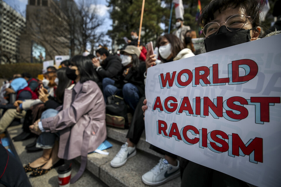 지난 3월 20일 서울 중구 파이낸스빌딩 앞 계단에서 열린 2022 세계 인종차별 철폐의 날 기념대회에 참가한 이주민 및 참석자들이 피켓을 들고 있다. [사진제공=뉴시스]