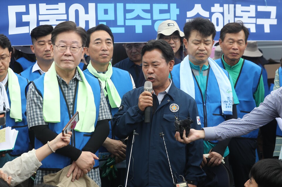 25일 오전 충남 부여군 부여읍 정동리 수해 복구 지원활동에 나선 이재명 더불어민주당 대표 등이 피해 상황을 취재진에게 설명하고 있 박정현 부여군수의 발언을 경청하고 있다. [사진제공=뉴시스]