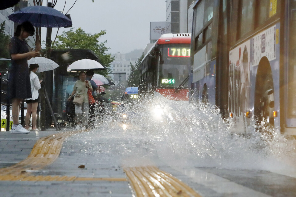 태풍 카눈이 수도권으로 북상 중인 지난 10일 오후 서울 광화문 네거리에서 차량들이 물보라를 일으키며 지나가고 있다. [사진제공=뉴시스]