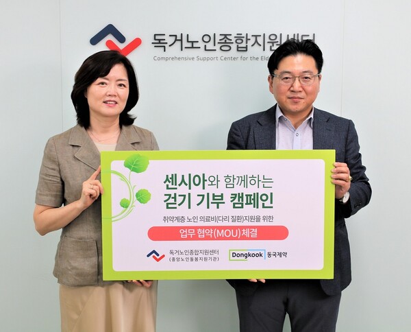 동국제약 OTC마케팅부 박혁 이사(오른쪽)와 독거노인종합지원센터 김현미 센터장이 지난 8월 30일 서울시 영등포구 독거노인종합지원센터에서 개최한 협약식에서 기념 촬영을 하고 있다.[사진제공=동국제약]