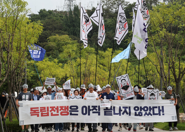 민족문제연구소 회원들과 시민들이 지난 17일 오후 서울 중구 남산예장공원에서 전쟁기념관까지 '홍범도 흉상 철거 규탄' 행진을 하고 있다. [사진제공=뉴시스]<br>
