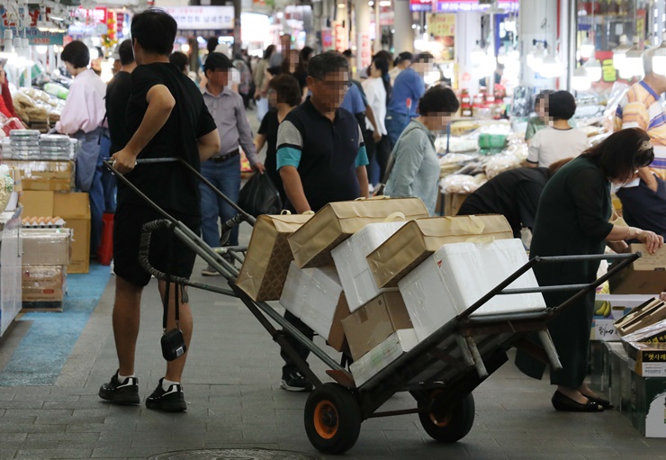 지난 22일 서울에 위치한 한 전통시장에서 상인이 추석 제수용품 선물세트 손수레로 옮기고 있는 모습. [사진제공=뉴시스]<br>