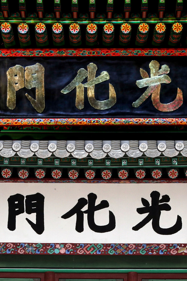 서울 종로구 광화문광장에서 열린 광화문 월대 및 현판 복원 기념식에서 지난 15일 현판이 공개됐다. 윗쪽 사진은 새로 설치된 검은색 바탕에 금빛 글씨로 쓰여진 현판, 아래쪽 사진은 철거된 기존 흰색 바탕에 검정 글씨로 쓰여진 현판. [사진제공=뉴시스]<br>