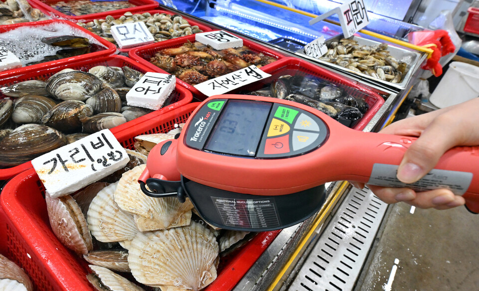 지난 8월 22일 경기도 수원시의 한 수산시장에서 관계자가 방사능 측정기로 수산물을 점검하고 있다. [사진제공=뉴시스]