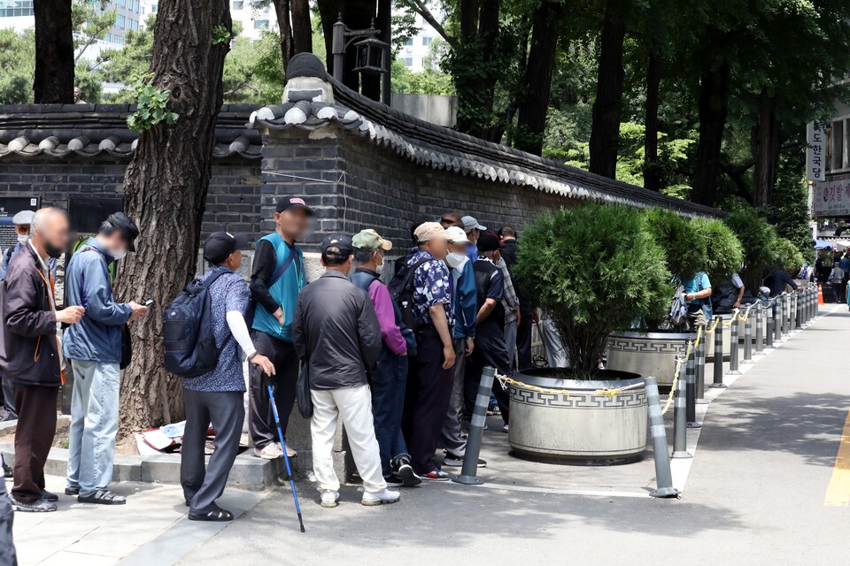 지난 6월 서울 종로구 탑골공원 인근에서 노인들이 무료 배식을 받기 위해 줄지어 서 있는 모습. [사진제공=뉴시스]