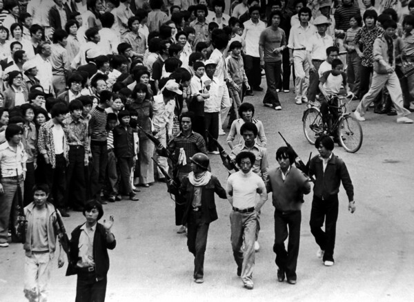 총을 든 청년들이 1980년 5월 24일 프락치나 간첩으로 의심되는 청년의 손을 뒤로 묶은 채 전남도청으로 연행하고 있다. [사진제공=뉴시스]
