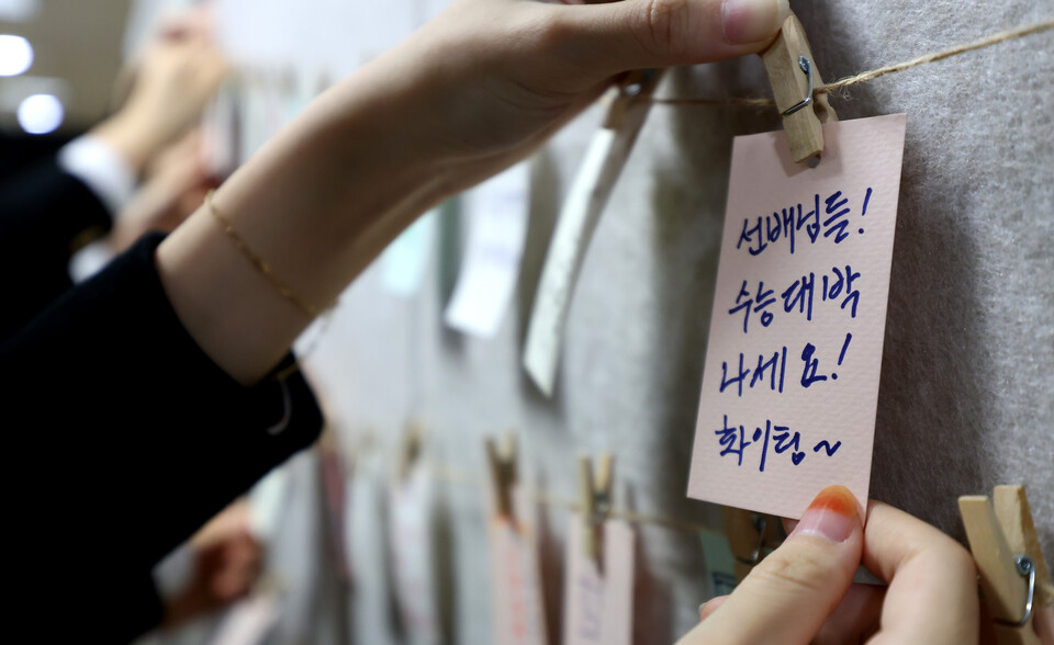 한 학생이 수능 응원 게시판에 수험생 선배들을 응원하는 메시지를 적고 있다. [사진제공=뉴시스]<br>