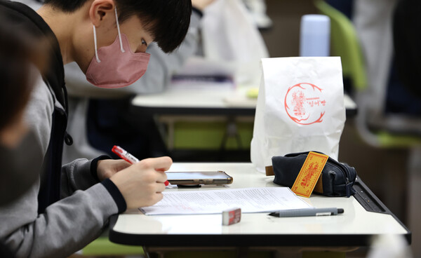 지난 6일 대구 북구 매천고등학교에서 한 수험생이 합격부적을 책상 위에 올려두고 문제를 풀고 있다. [사진제공=뉴시스]