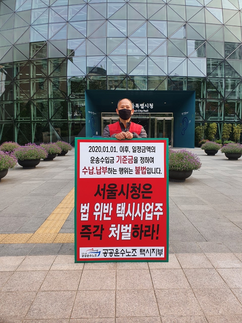 故(고) 방영환(55)씨가 생전 서울시청 앞에서 법 위반 택시사업주 처벌을 촉구하며 1인 피켓 시위를 진행하고 있다. [사진제공=공공운수노조 택시지부]<br>