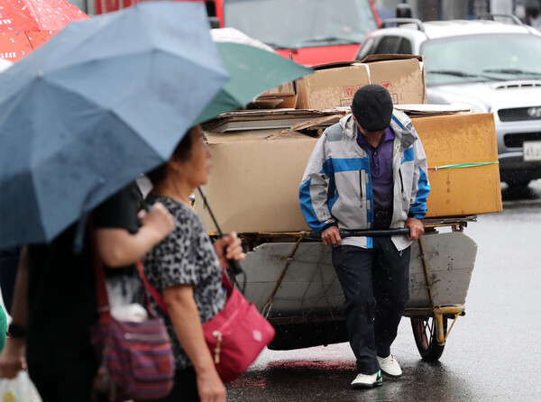 서울 시내 대로변의 한 노인이 폐지를 리어카에 싣고 발걸음을 재촉하고 있다. [사진제공=뉴시스]