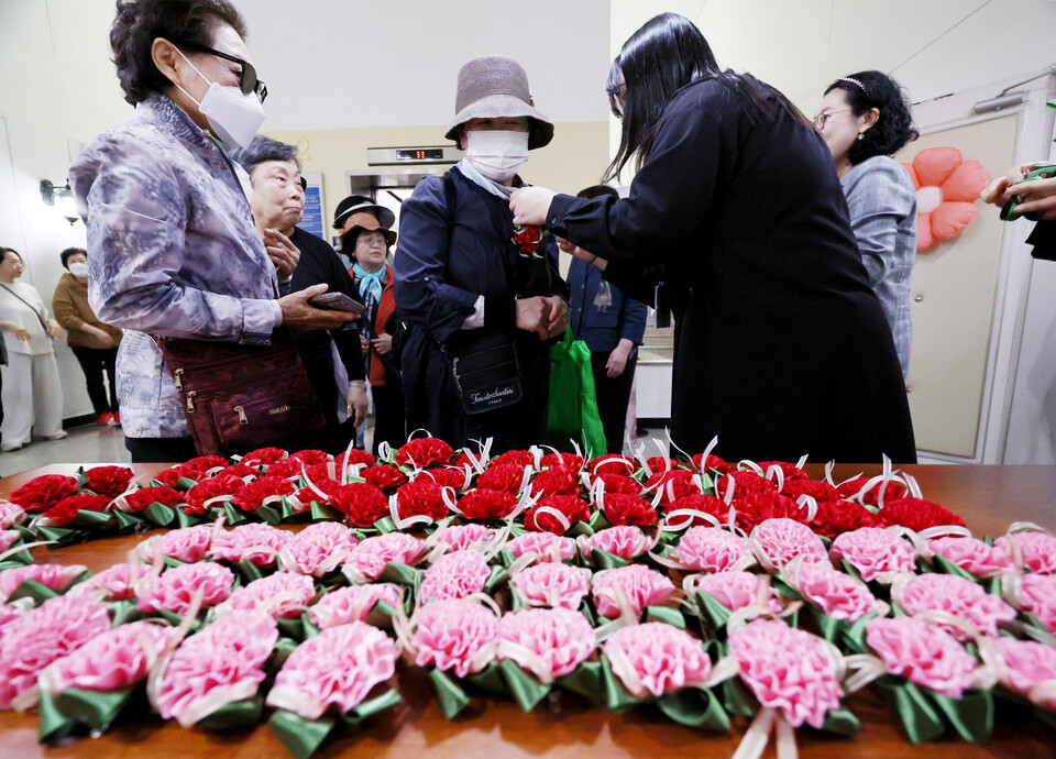 어버이날인 8일 서울 송파노인종합복지관에서 열린 ‘꽃처럼 찬란한 어르신, 감사해효(孝) 행사’에 참석한 어르신들이 카네이션을 달고 있다. [사진제공=뉴시스]