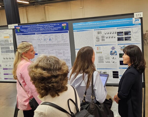 JW중외제약이 지난 15일부터 나흘간 미국 텍사스주 달라스에서 열린 미국 피부연구학회에서 자사 Wnt 표적 탈모치료제 ‘JW0061’의 모낭생성·모발성장 효능을 발표했다. JW중외제약 유안나(오른쪽 첫 번째) 신약2팀장이 참가자들에게 연구결과를 설명하고 있다. [사진제공=JW중외제약]